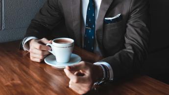 Man wearing suit drinking a coffee