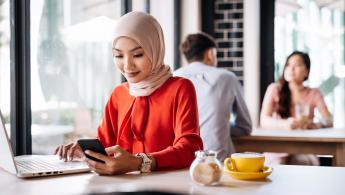 Woman in cafe looking at mobile phone