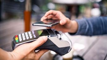 Close up of Person Paying at retail terminal using Aman Pay QR