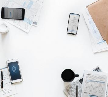 mobile phones and paperwork on a white table